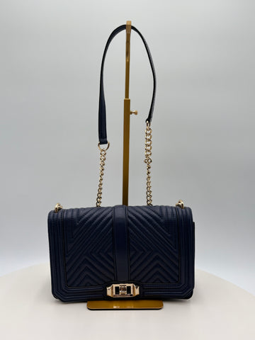 Navy blue handbag with gold accents on a white background