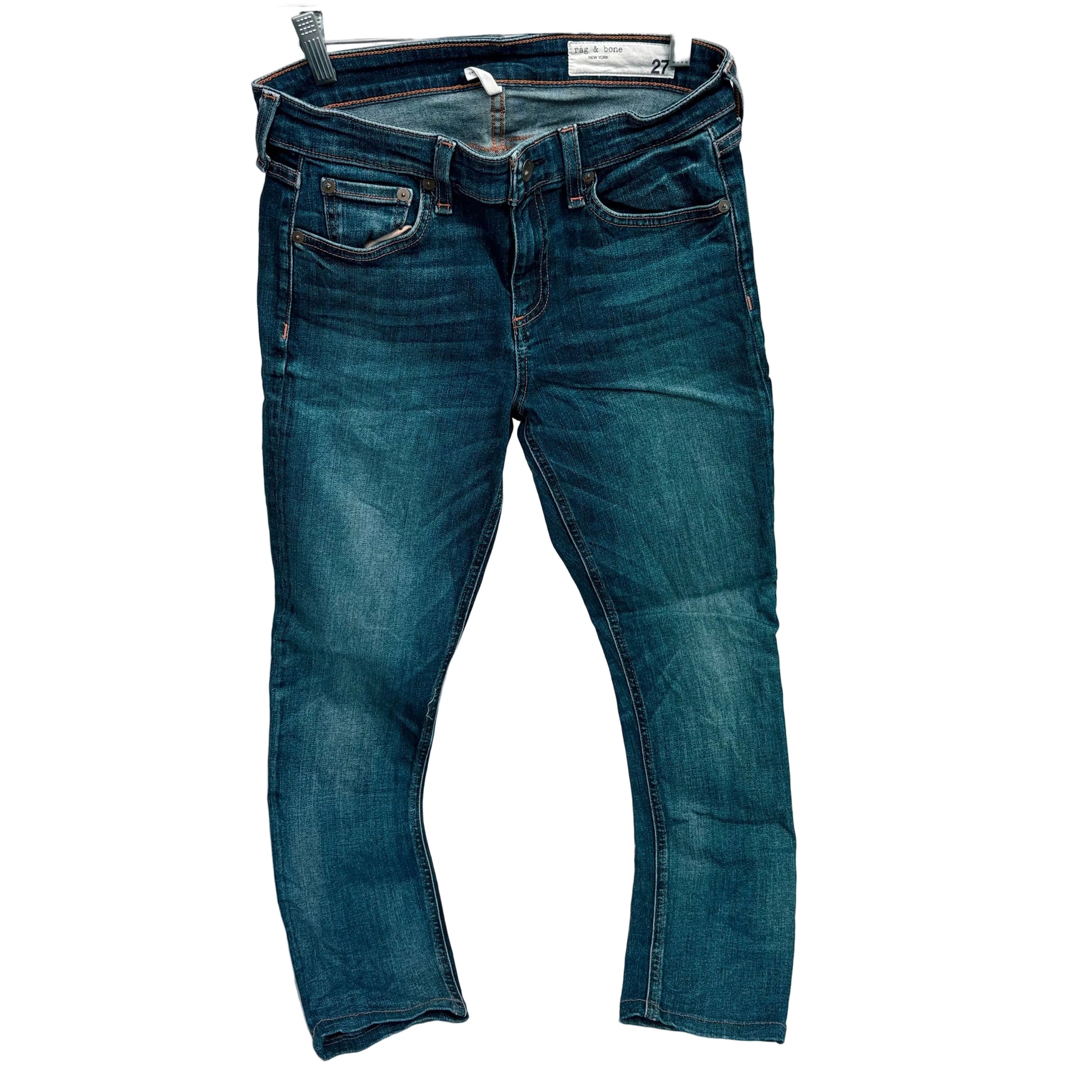 Pair of blue jeans on a hanger against a white background