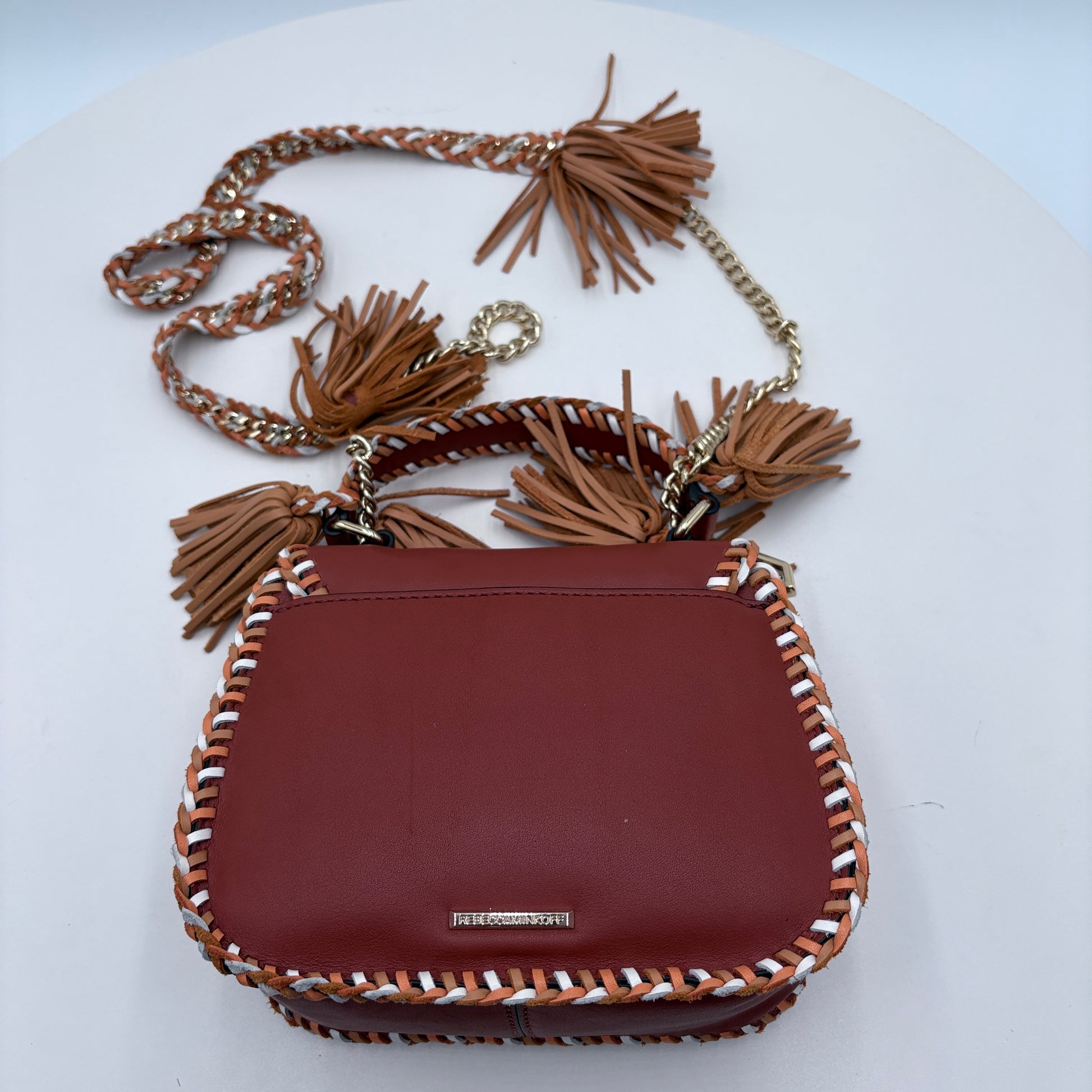 Brown handbag with tassels on a white background