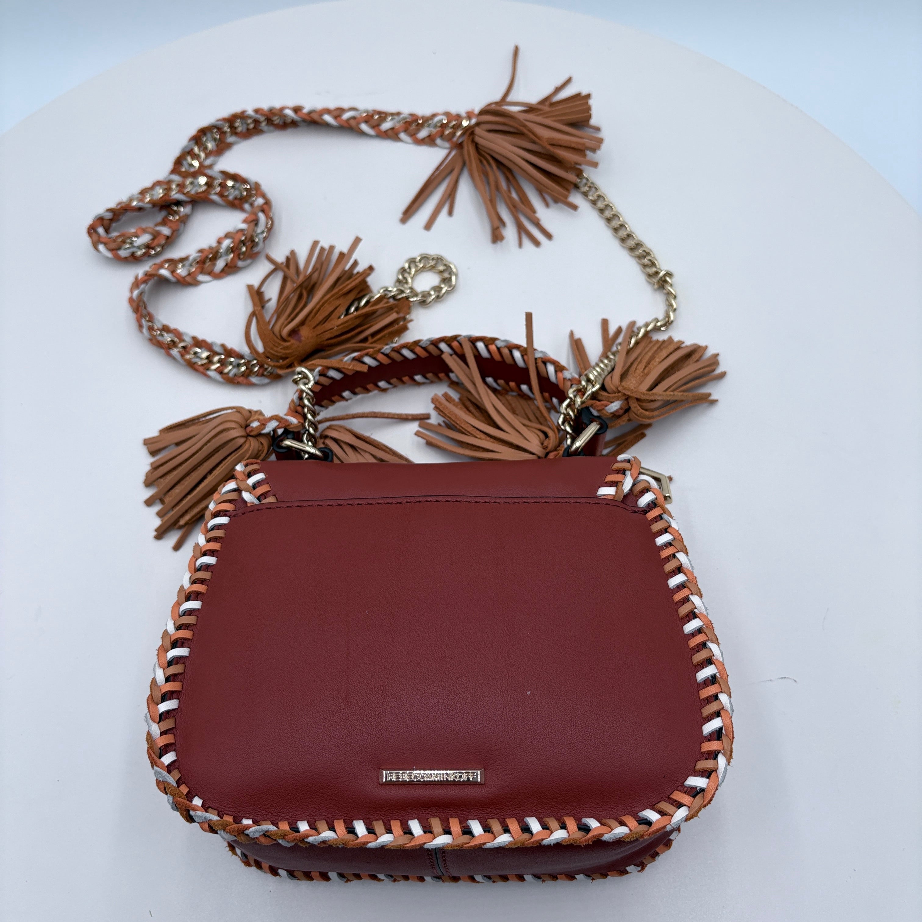 Brown handbag with tassels on a white background