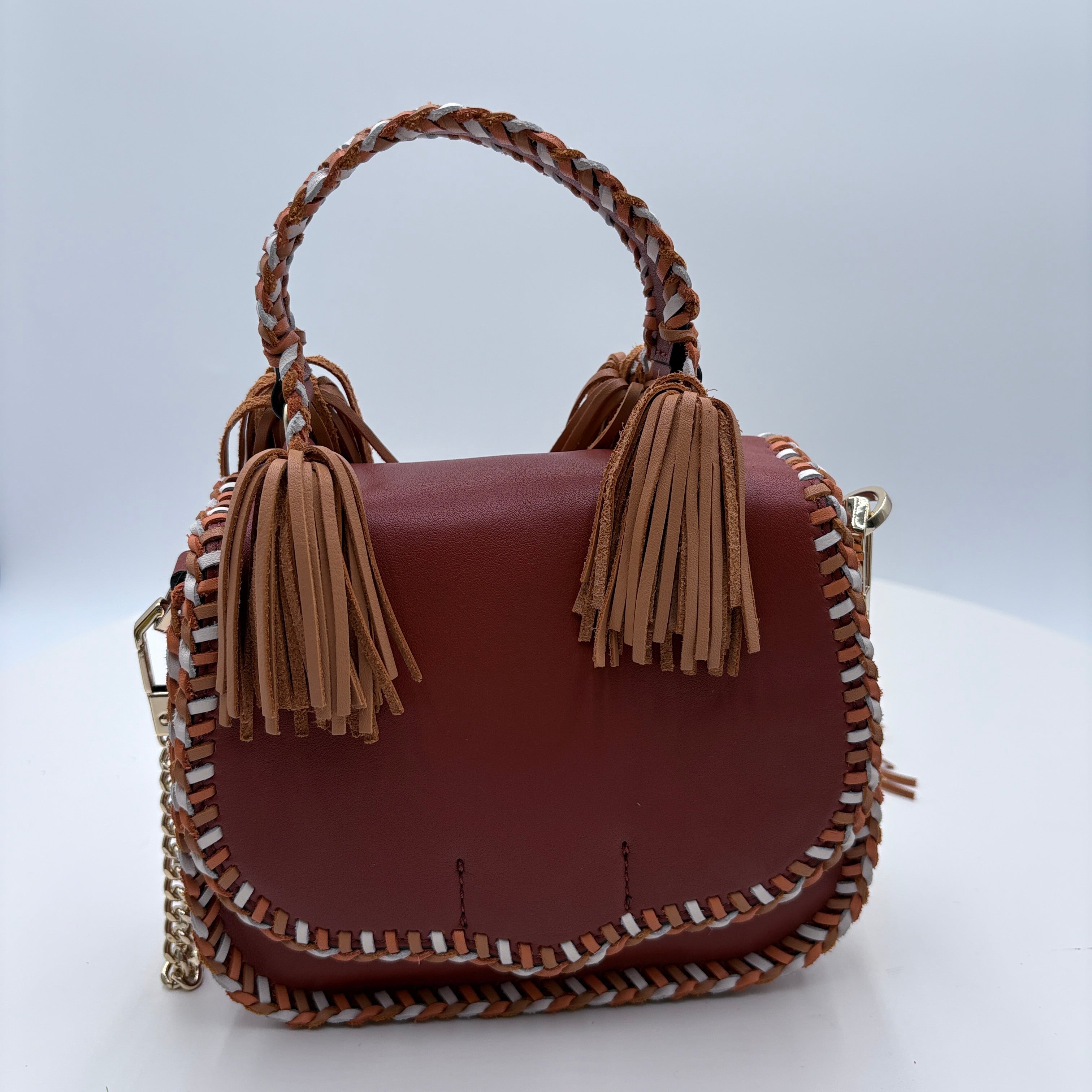 Brown handbag with tassels on a white background