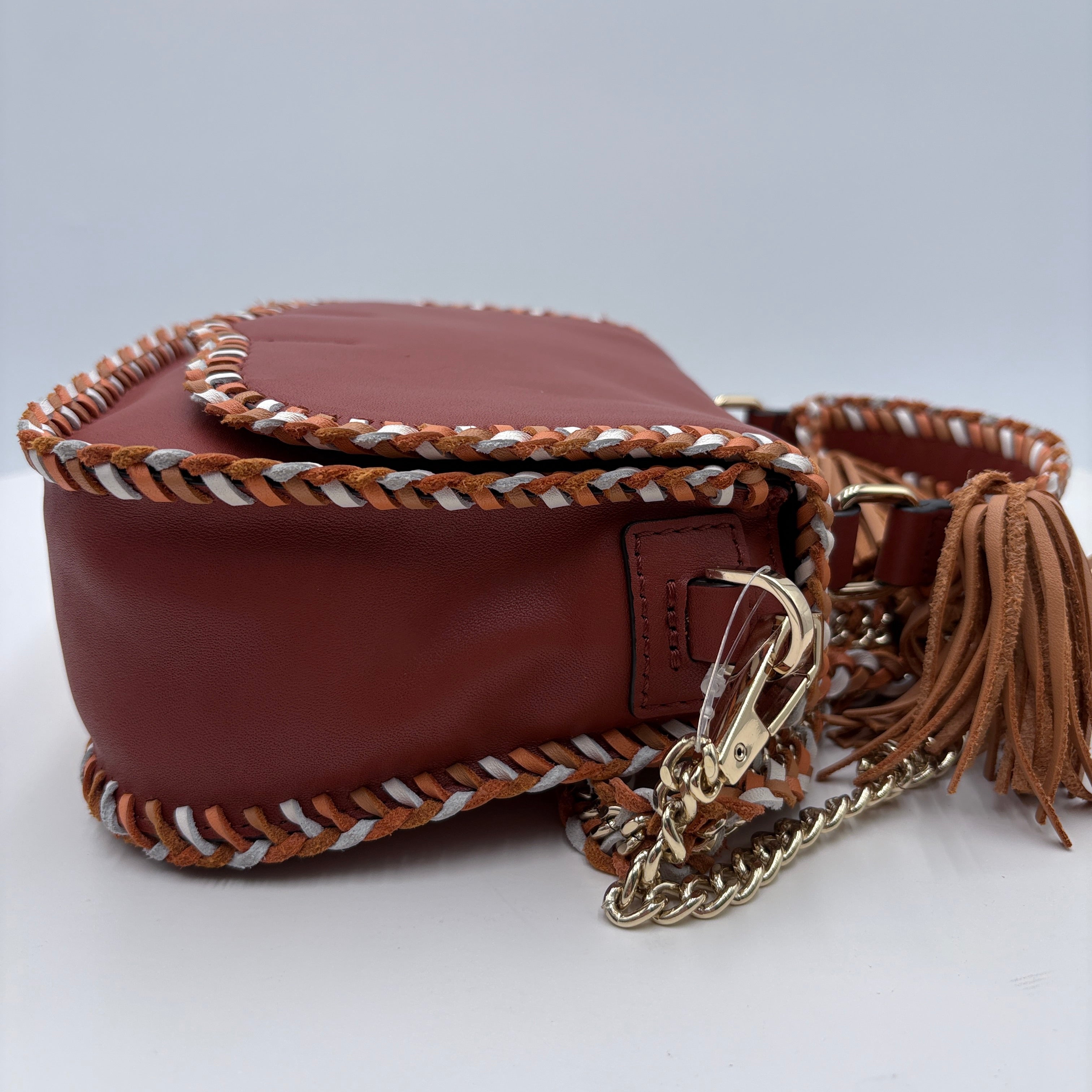 Brown leather handbag with braided handle and gold chain on a white background