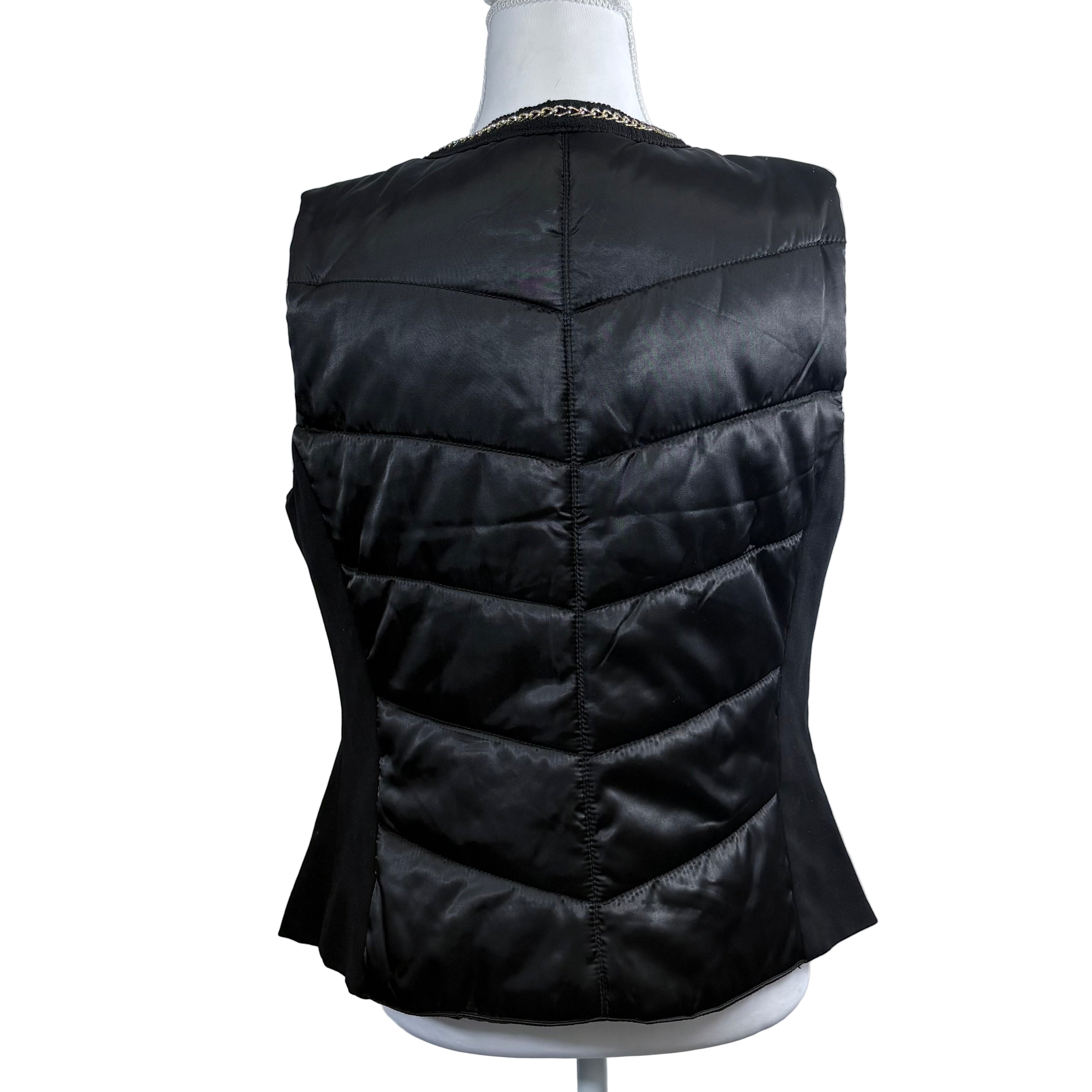 Black puffer vest on a mannequin against a white background