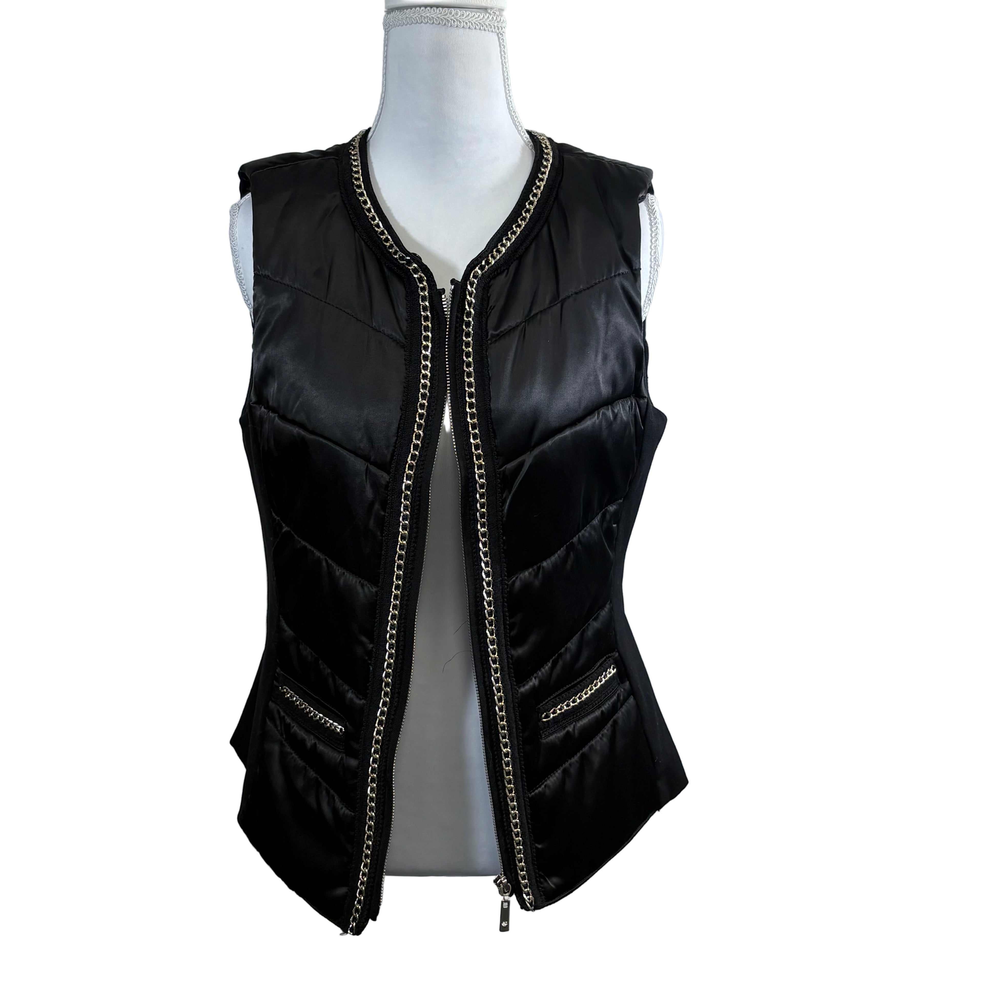 Black quilted vest with chain details on a mannequin against a white background