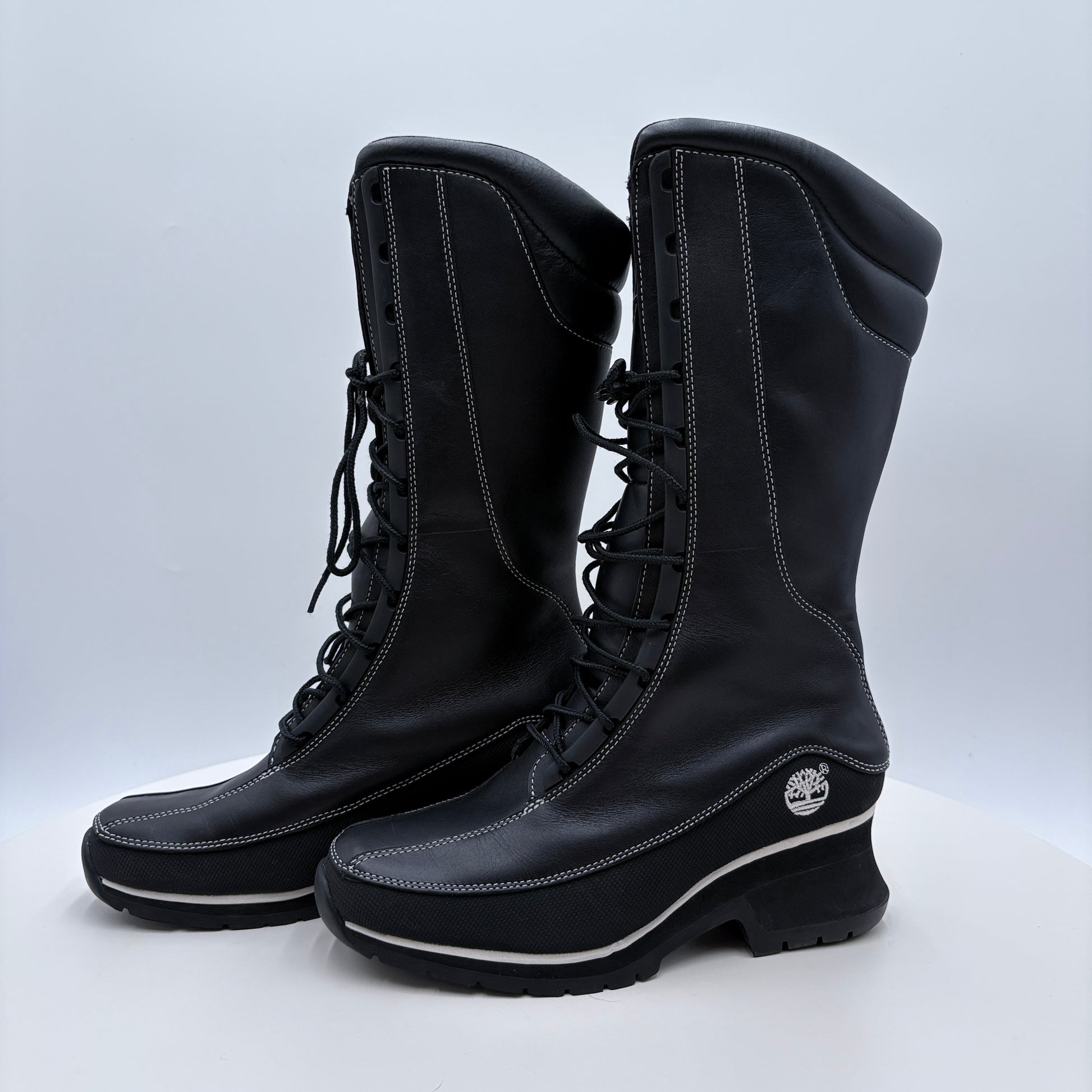 Pair of black boots with a visible brand logo on a white background