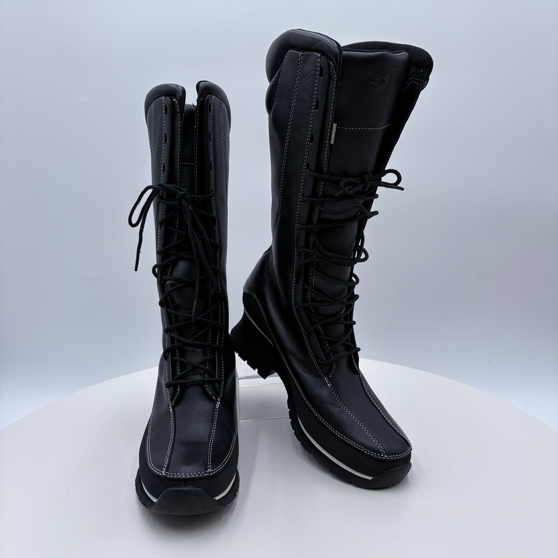 Black knee-high boots with laces on a white background