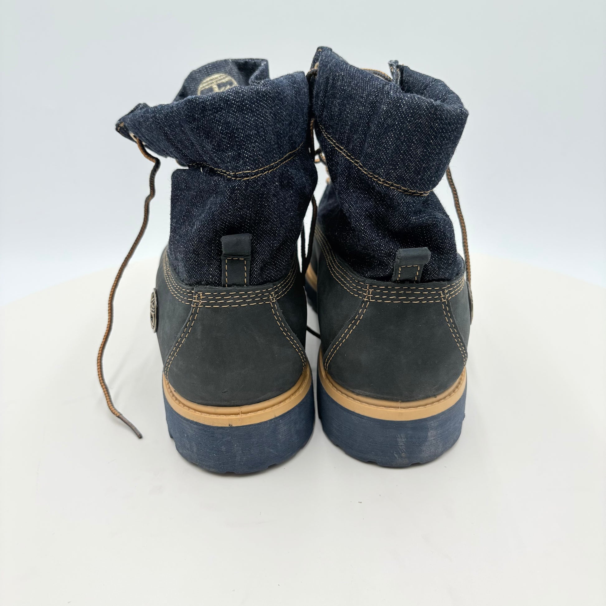 Pair of blue boots with brown soles on a white background