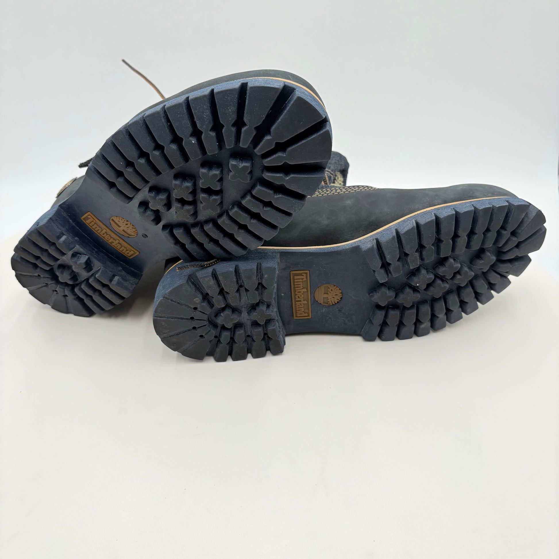 Black boots with tread pattern on a white background