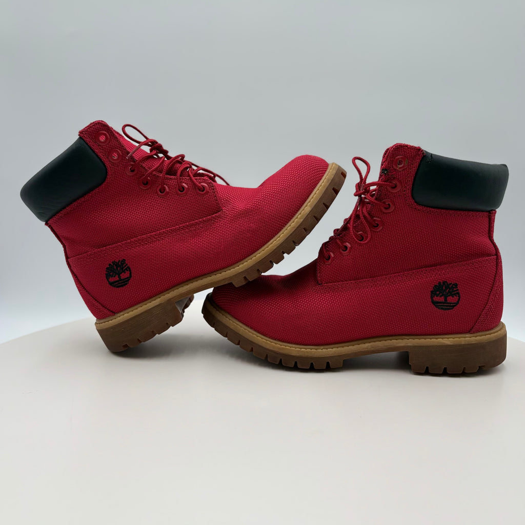 Red boots with black soles and visible brand logo on a white background