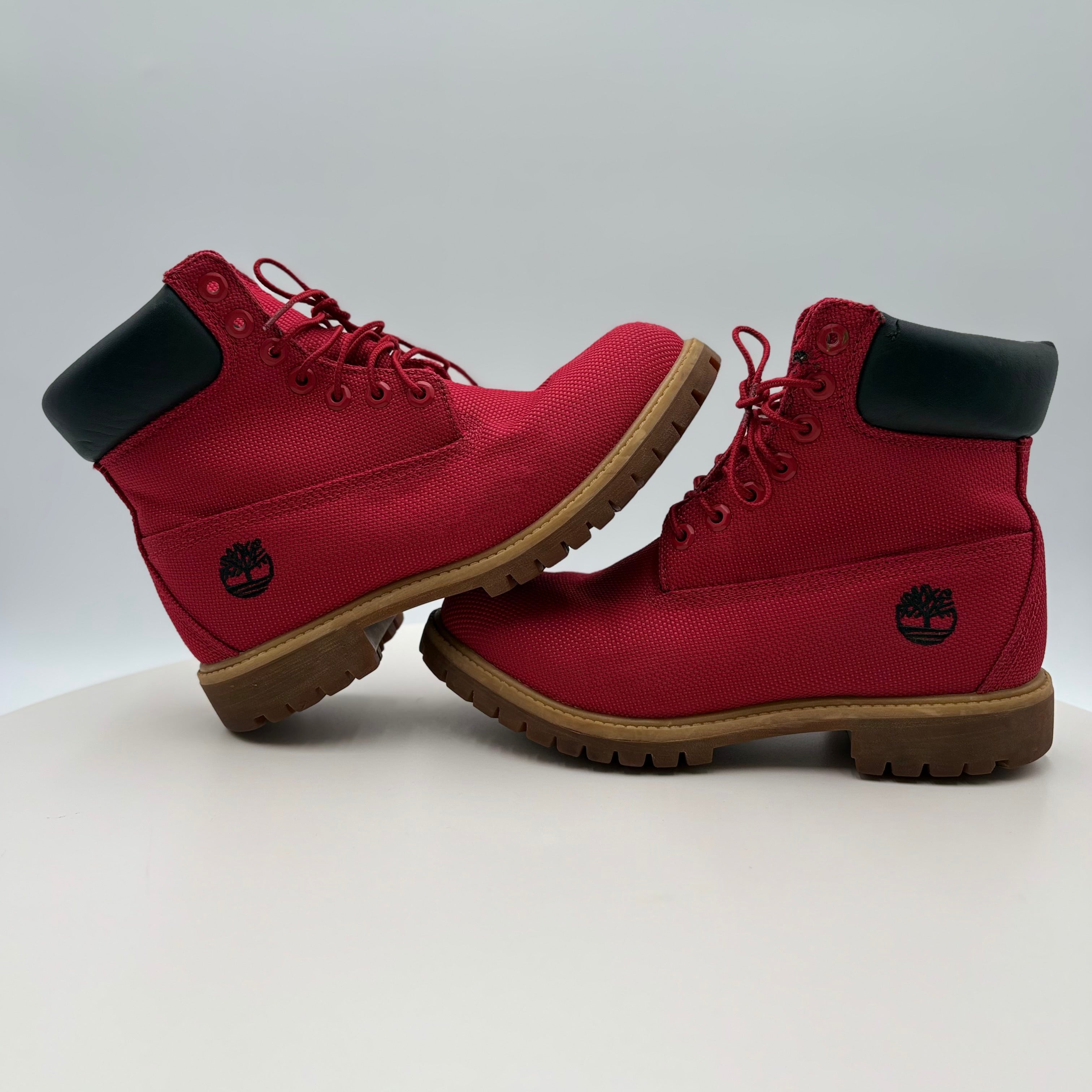 Red boots with black soles and visible brand logo on a white background
