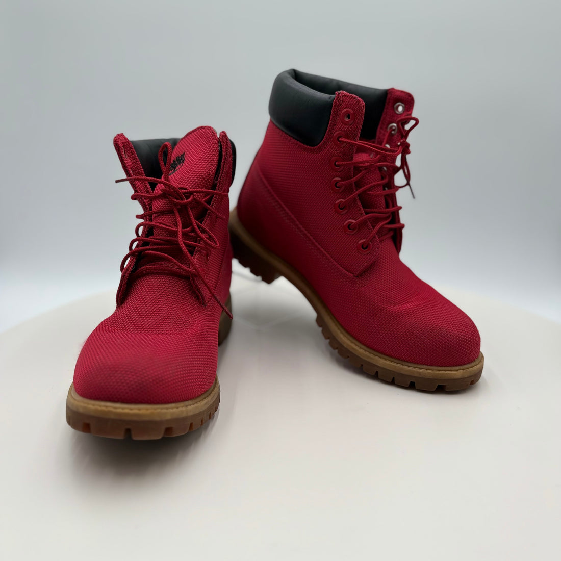 Pair of red boots with brown soles on a white background