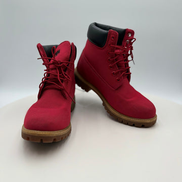 Pair of red boots with brown soles on a white background