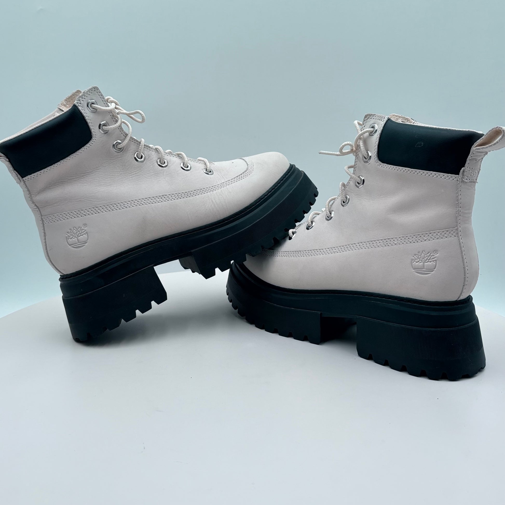 White Timberland boots with black soles on a light gray background