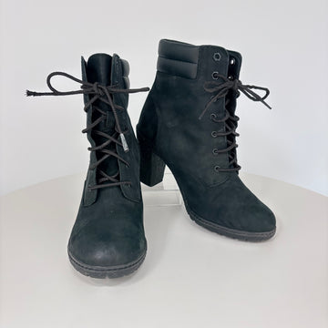 Pair of black lace-up boots on a white background
