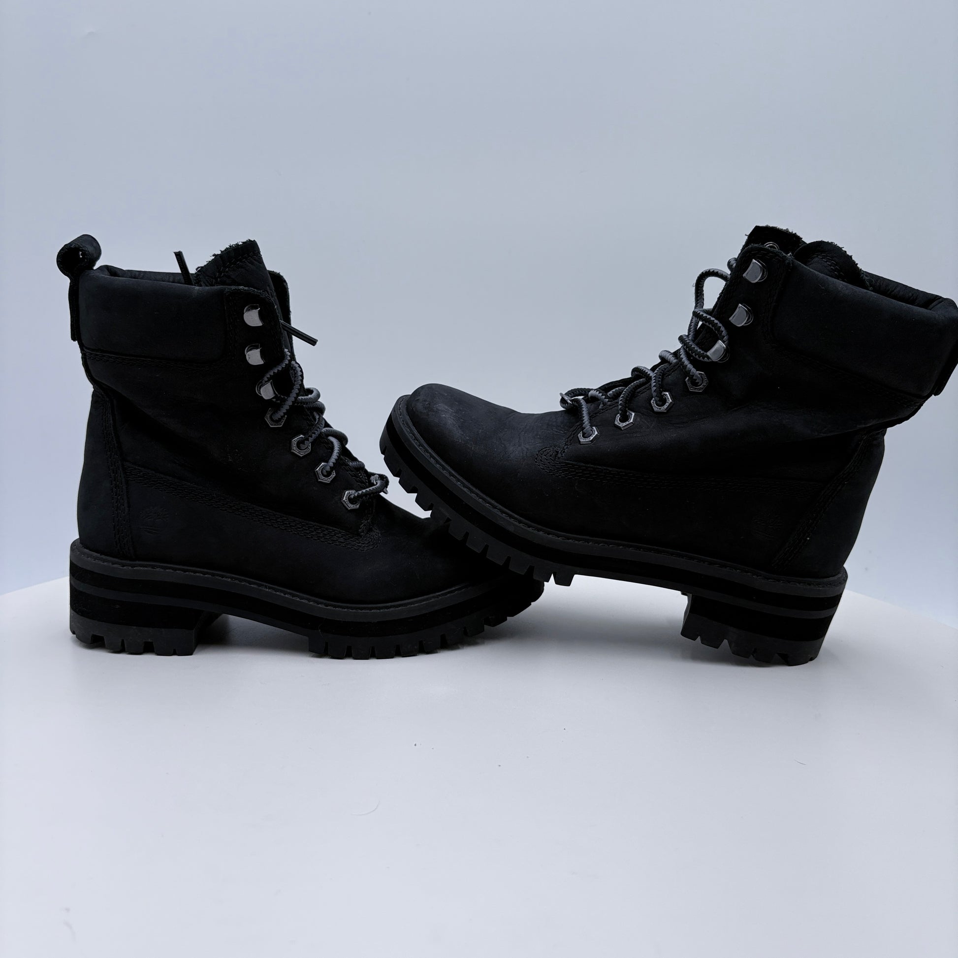 Pair of black boots on a light gray background