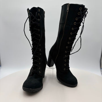 Pair of black knee-high boots with laces and a zipper on a white background
