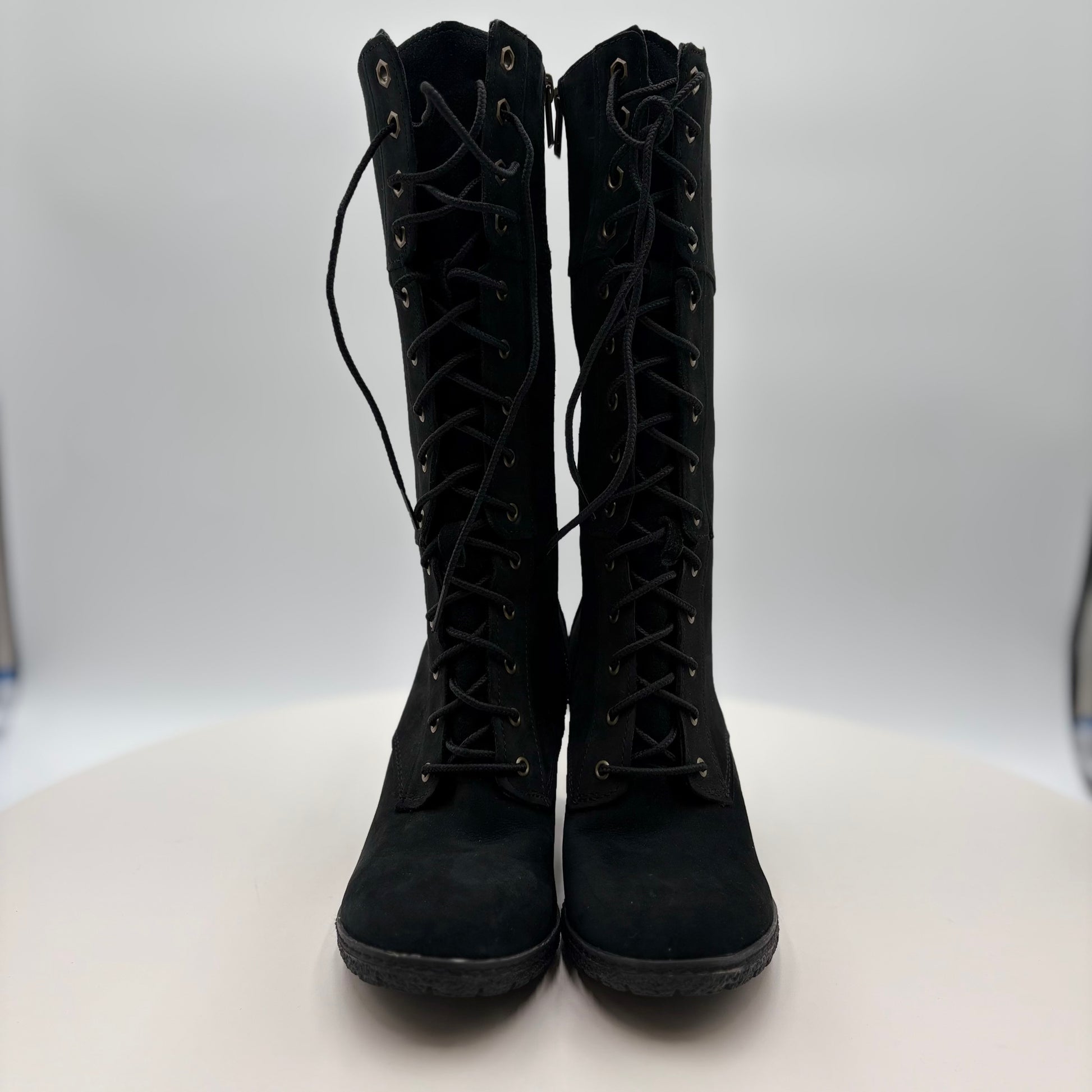 Pair of black lace-up boots on a white background