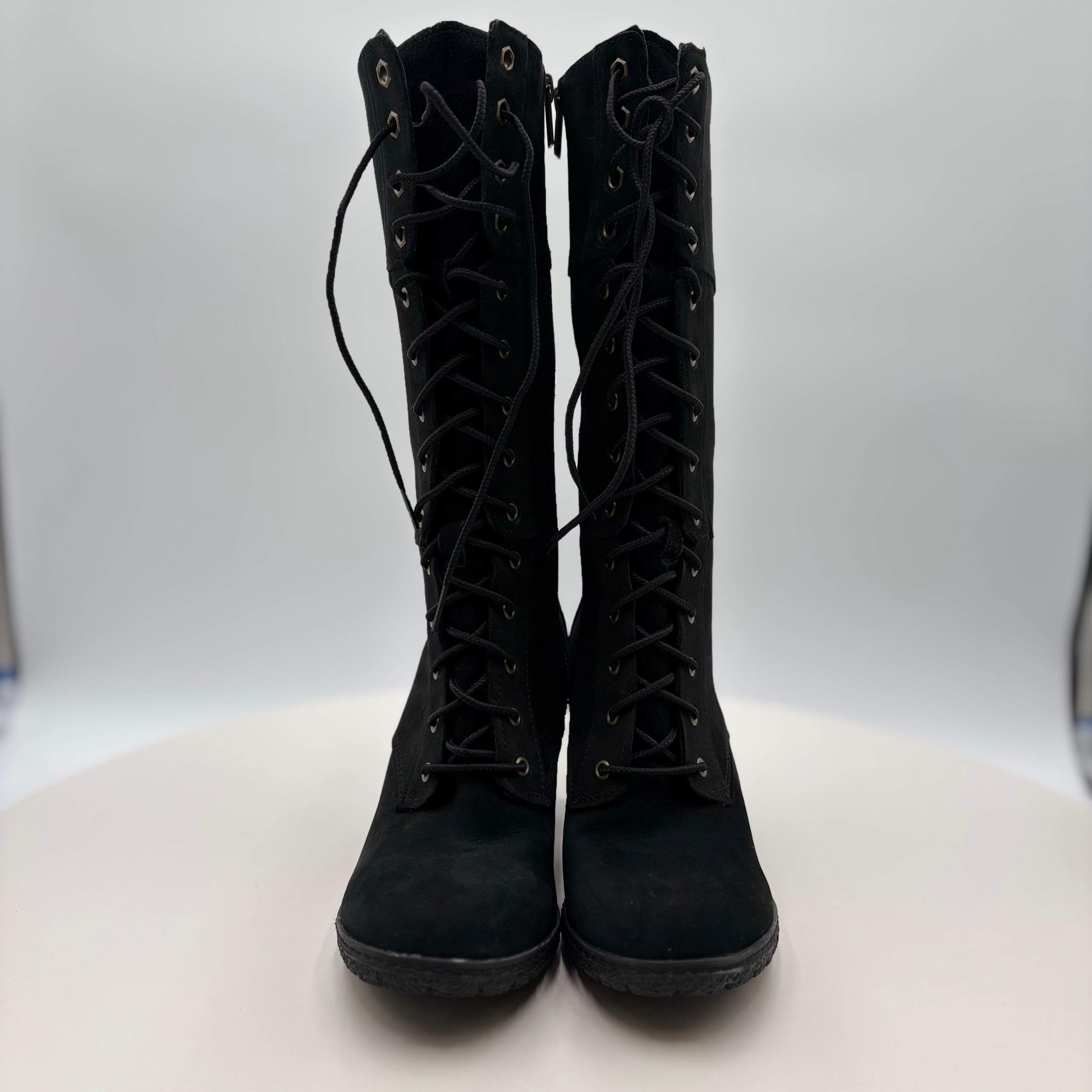 Pair of black lace-up boots on a white background