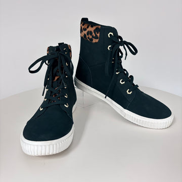 Black high-top sneakers with white soles on a light gray background