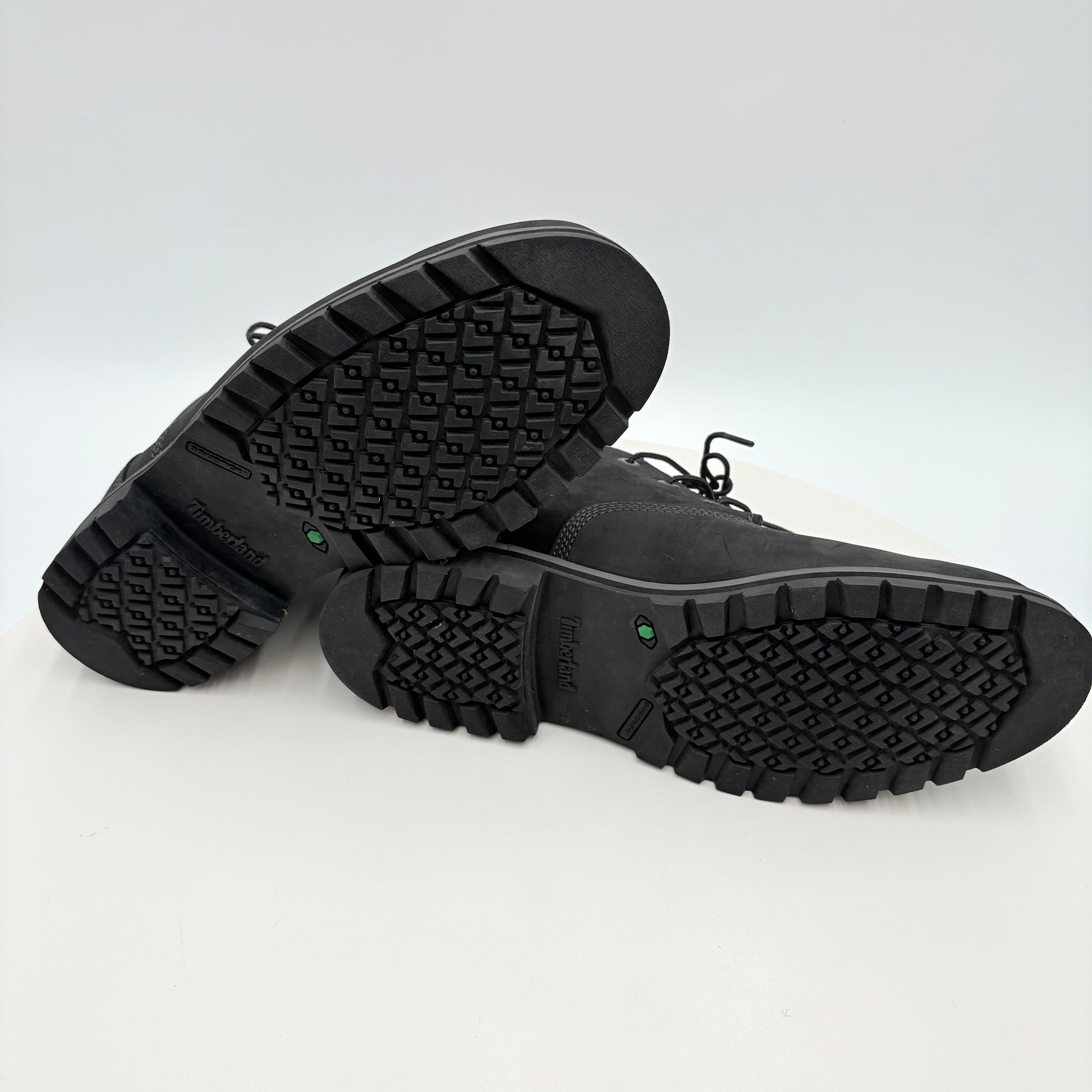 Black boots with treaded soles on a white background