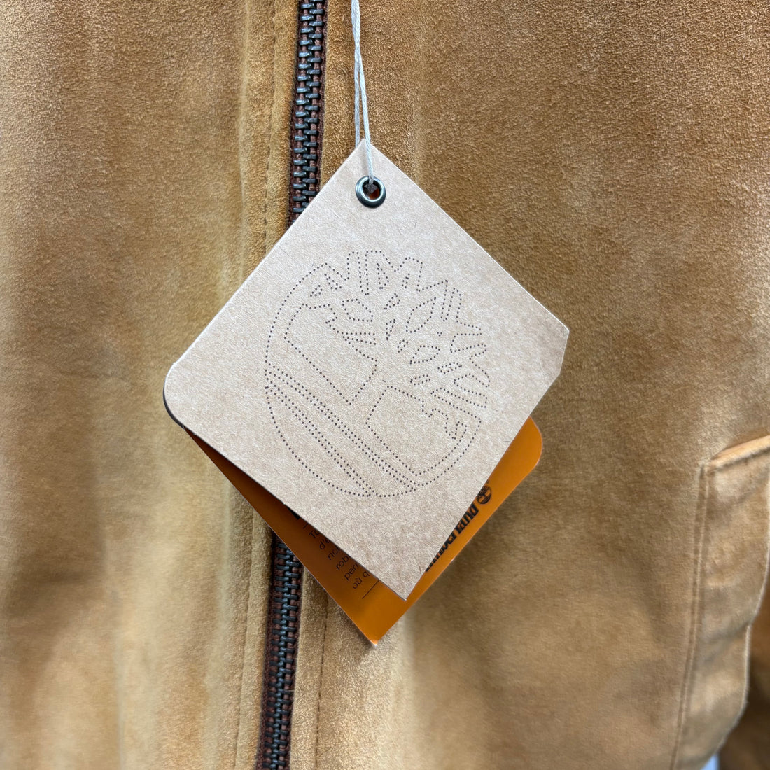 Brown suede jacket on a mannequin against a white background