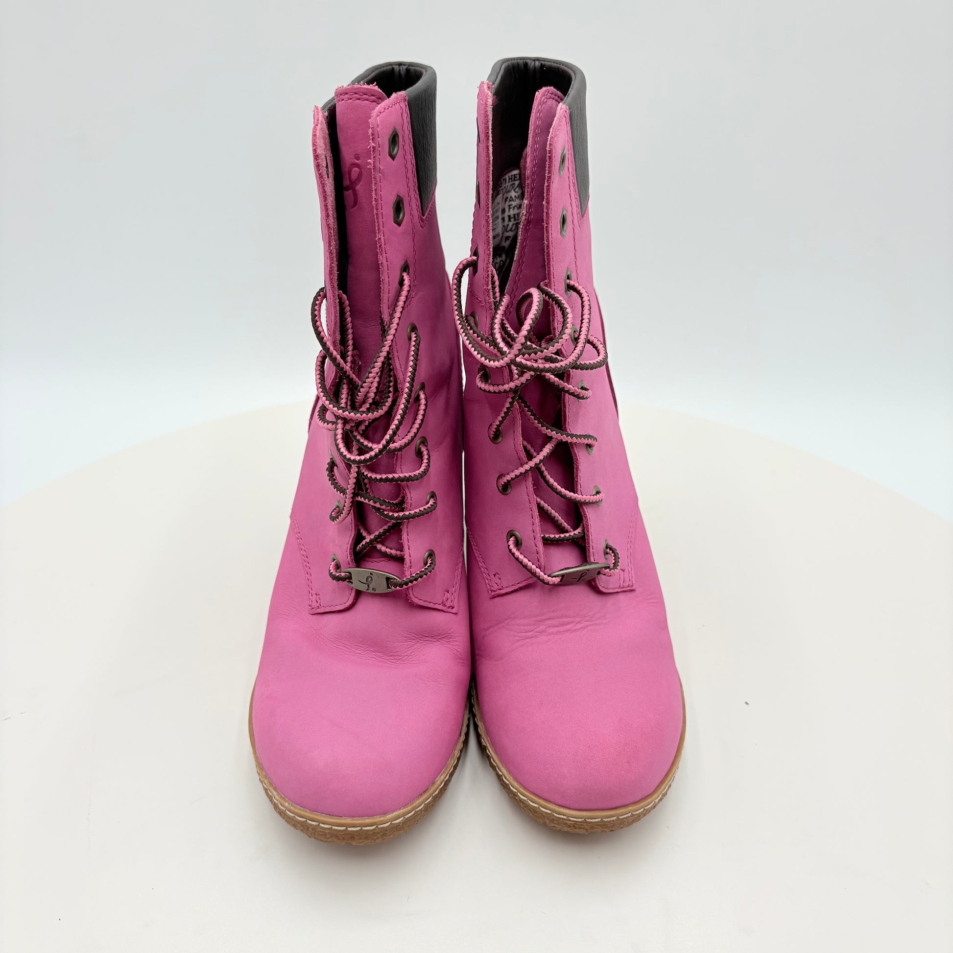 Pink boots with brown soles on a white background