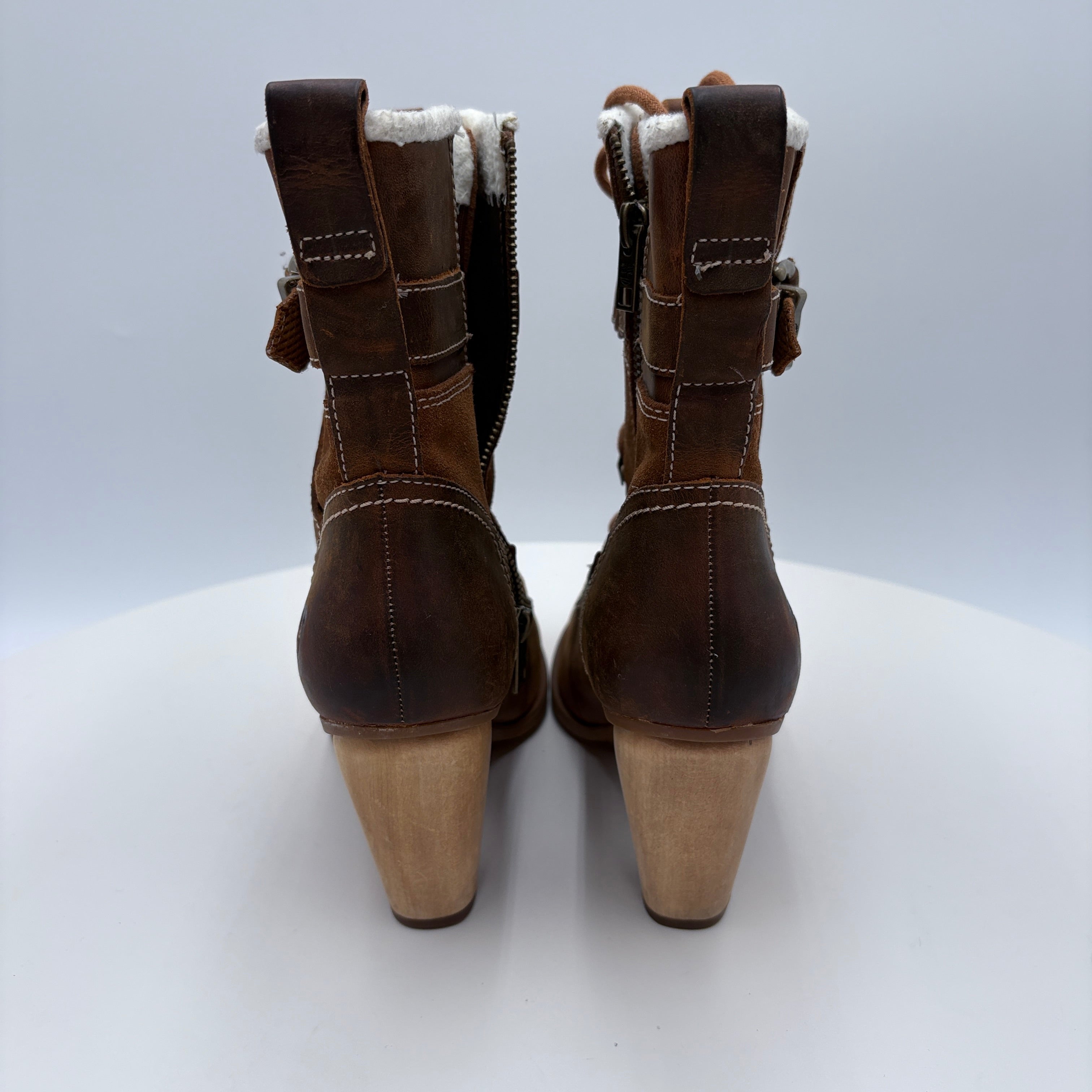Pair of brown suede boots with beige soles on a white background