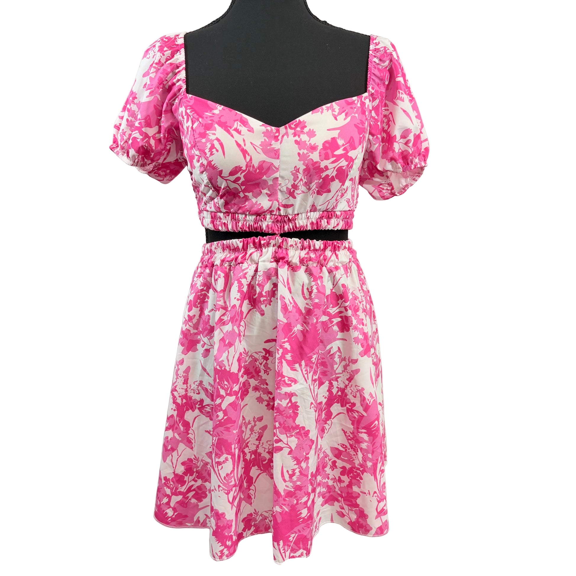 Pink and white floral dress on a mannequin against a white background