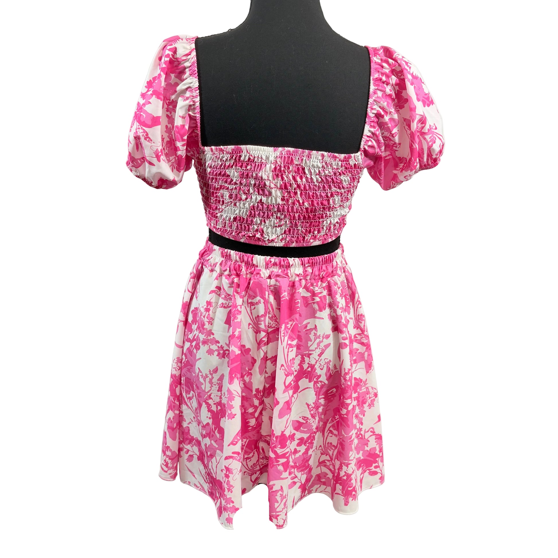 Pink and white floral dress on a mannequin against a white background