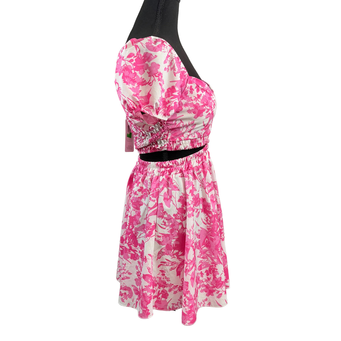 Pink and white floral dress on a mannequin against a white background