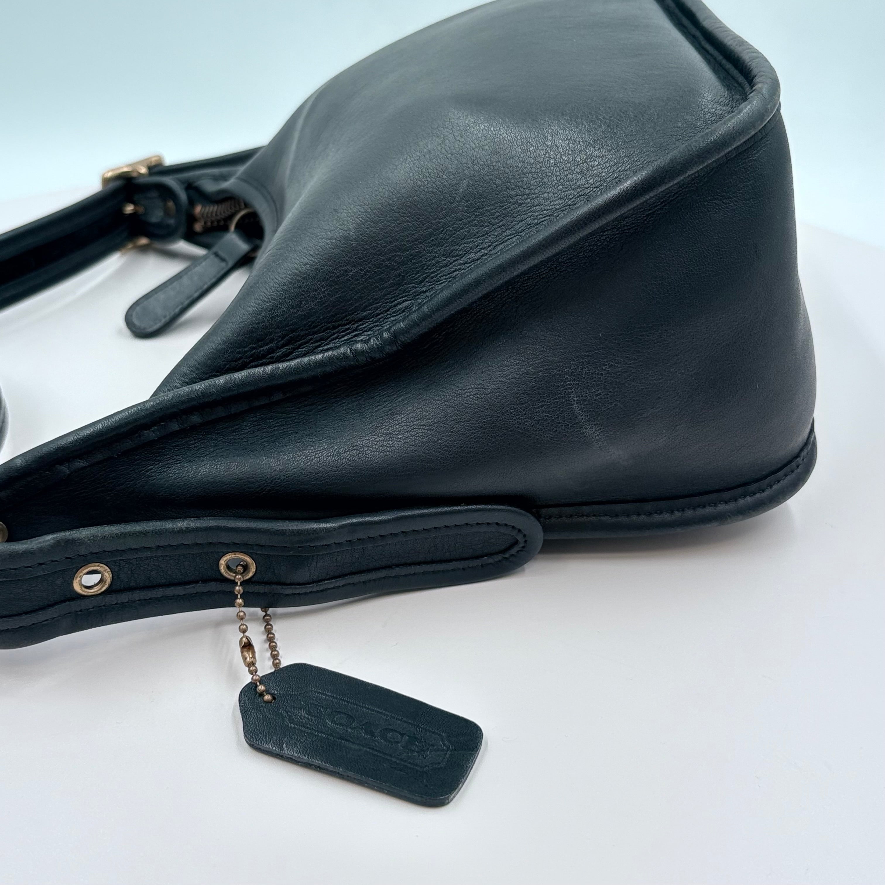 Black leather bag with a tag on a white background