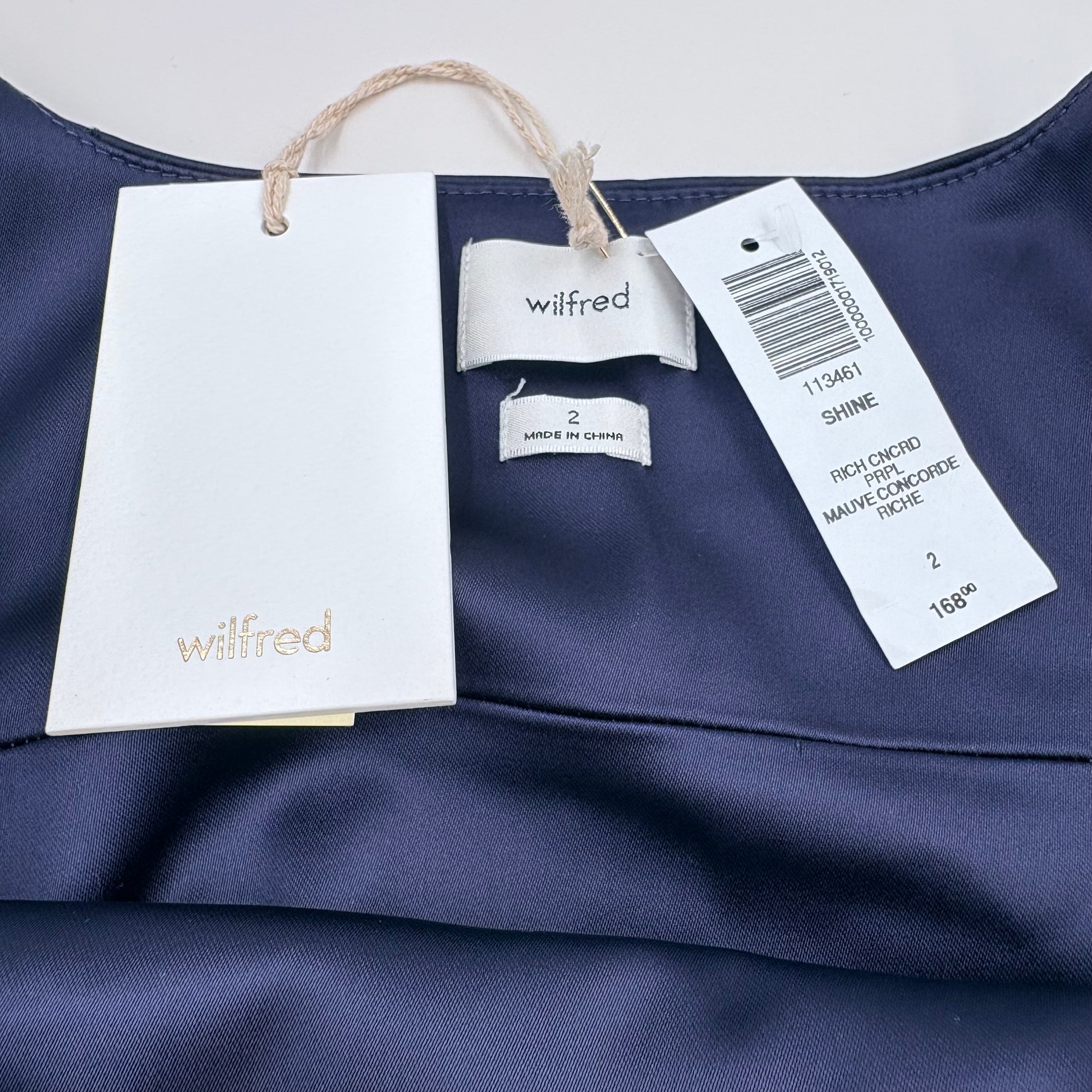 Concord Purple fabric with Wilfred brand tags on a white background