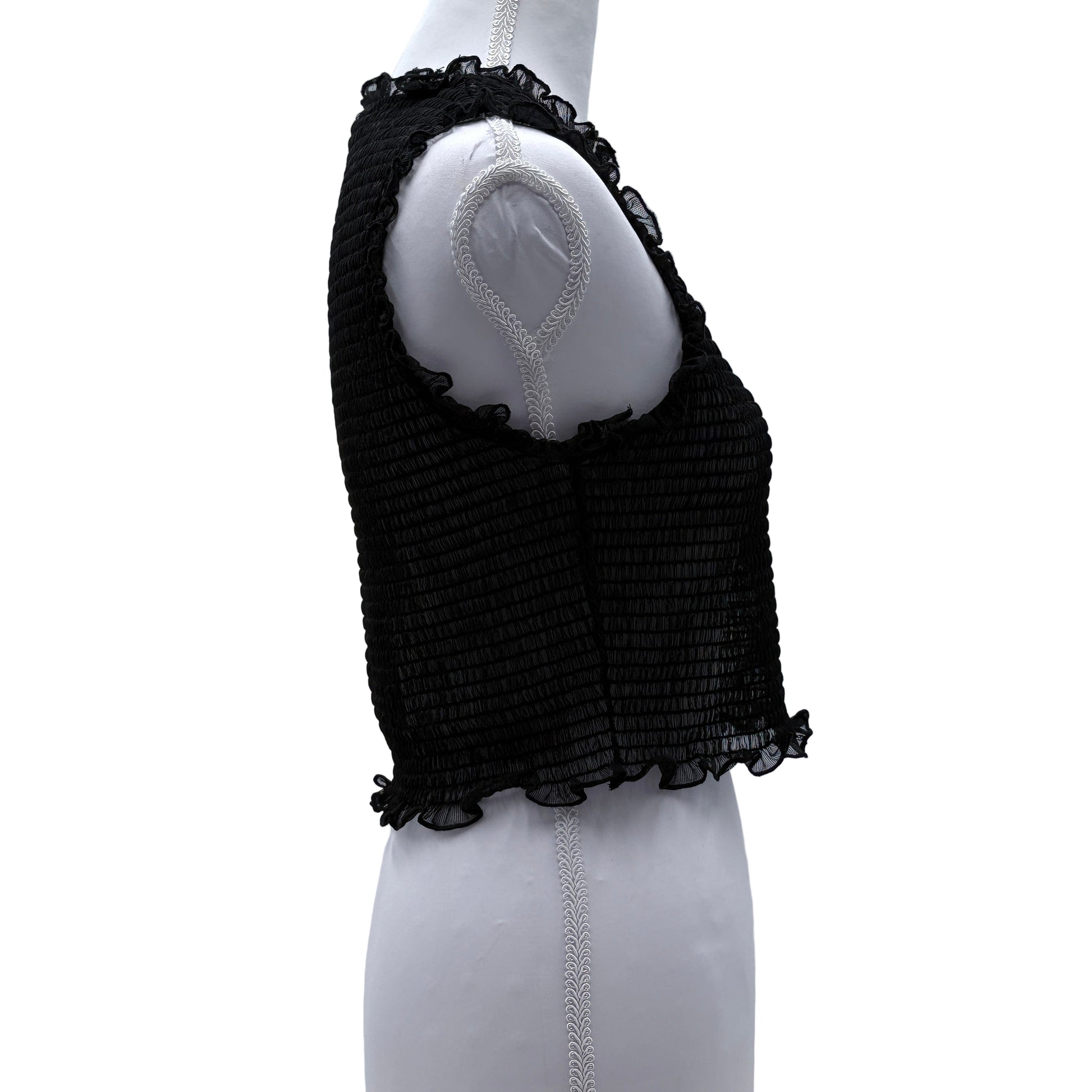 Black textured sheer sleeveless top on a mannequin arm against a white background